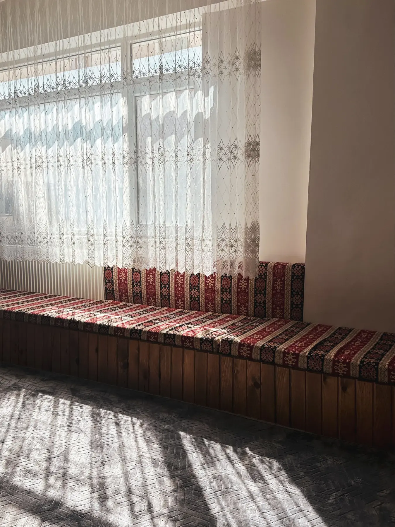 Kilim desenli sünger minderlerle döşenmiş pencere önü oturma alanı